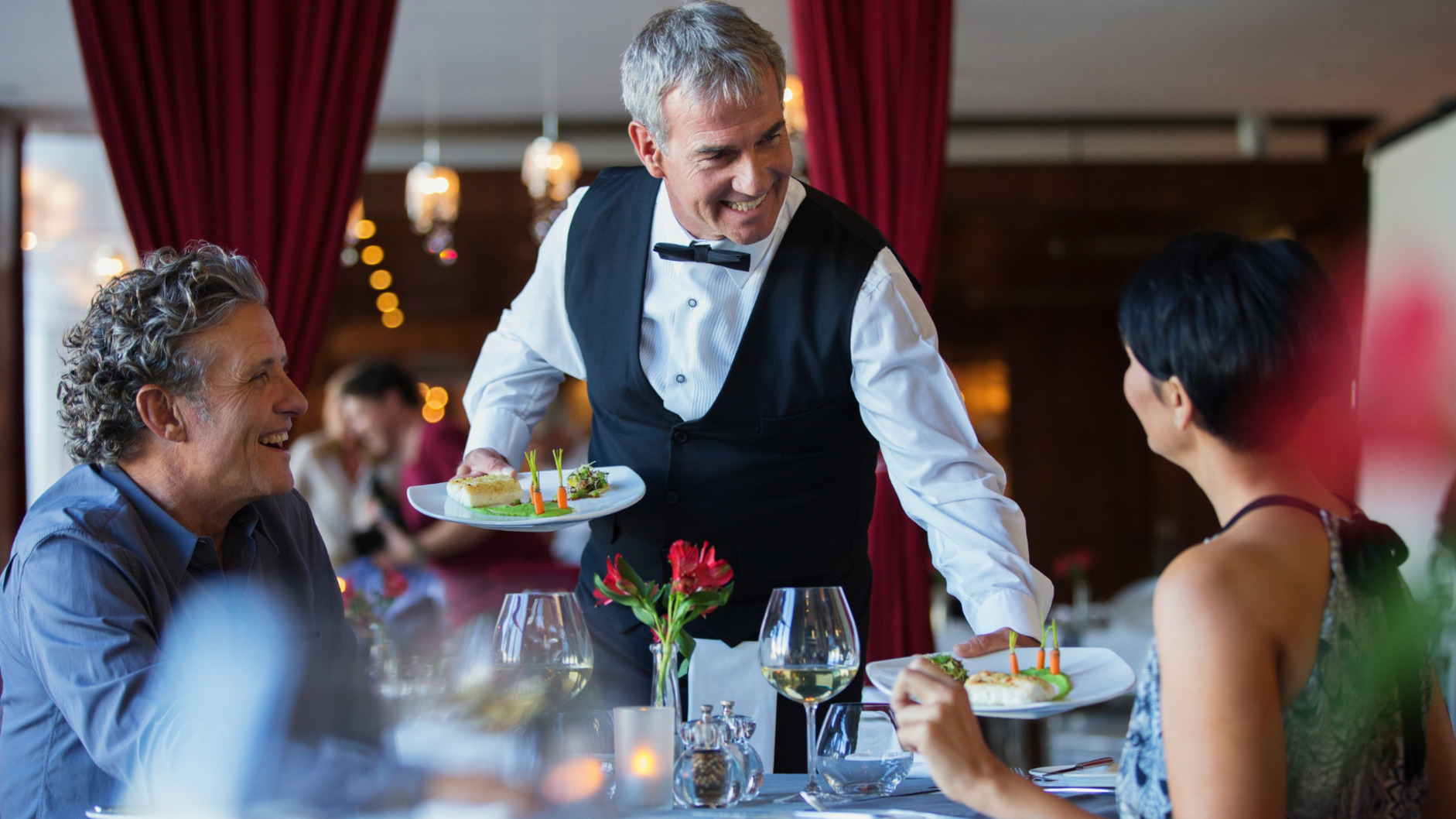 Picture of a waiter serving food to customers